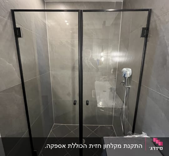 מקלחון חזית זכוכית עם פרופיל שחור בחדר רחצה מעוצב